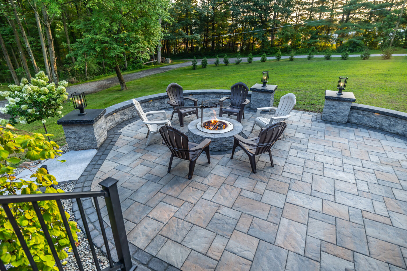 A Breeo fire pit surrounded by shale grey Mini creta wall blocks edged with a Villagio Onyx black boarder creates a dramatic centerpiece in this hardscape installation in Kunkletown, PA