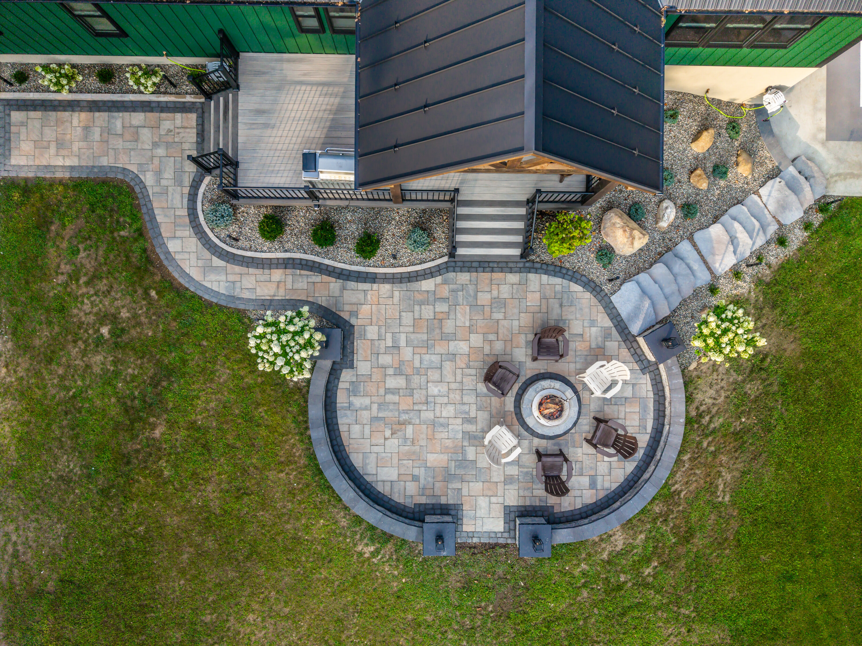 A Techo bloc Blue 60 paver firepit patio with a paver walkway and natural stone step entryway hardscape installation in Kunkletown PA