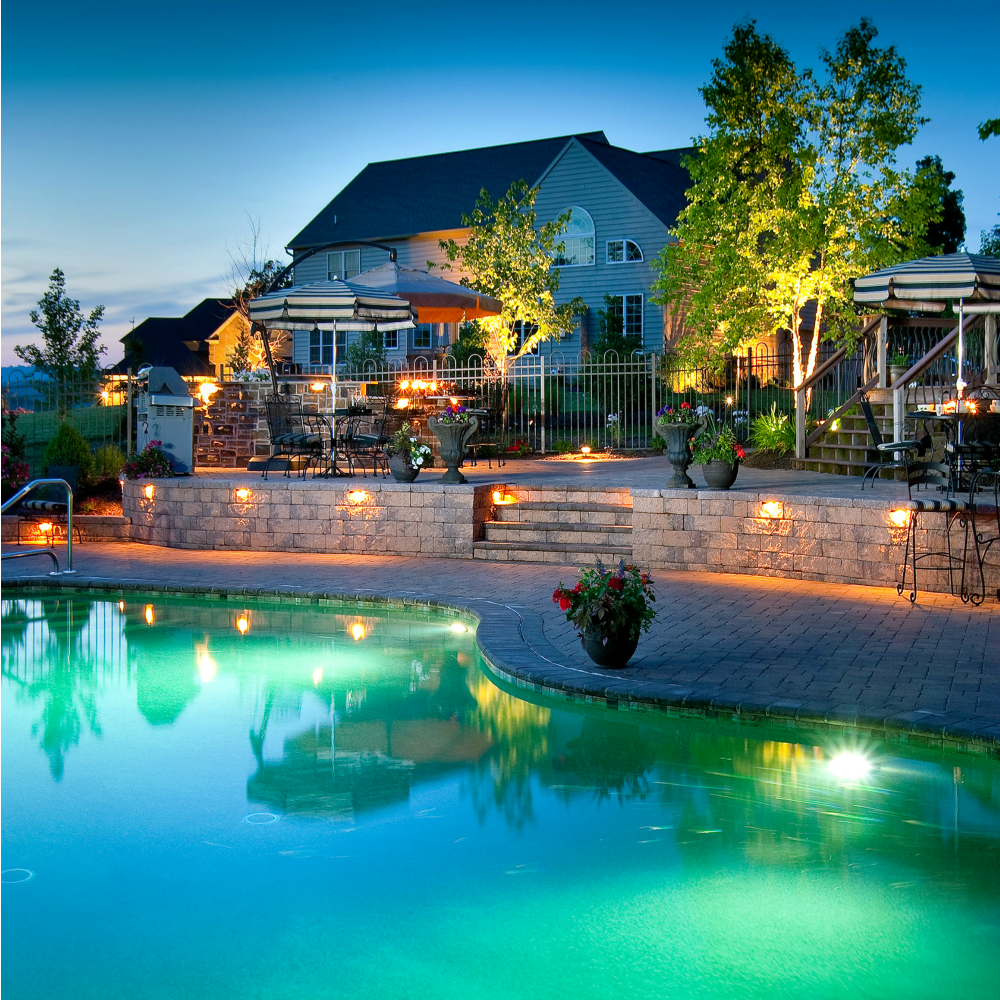 paver lights in steps and walls around pool illuminated at night
